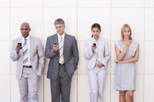 Business colleagues reading an SMS while in a line